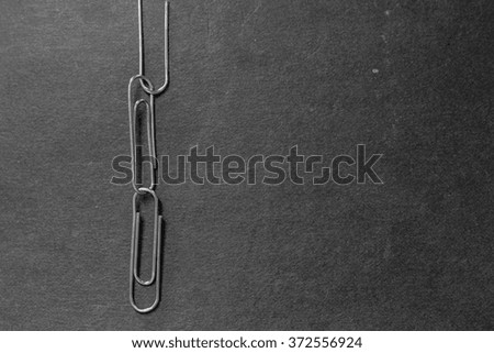 Three silver paper clips with black background