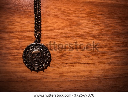 Picture of a pirate medallion on a wooden background with space for text