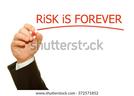 Businessman hand writing Risk is forever on a transparent wipe board