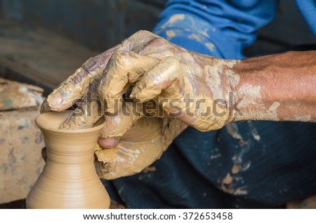 Hands of making clay pot on the pottery wheel.  Ban Tha Hai in Ubonratchathani, Thailand ,select focus, close-up.