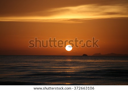 The landscape photography of orange sun setting into the ocean in the sea on koh samui Thailand