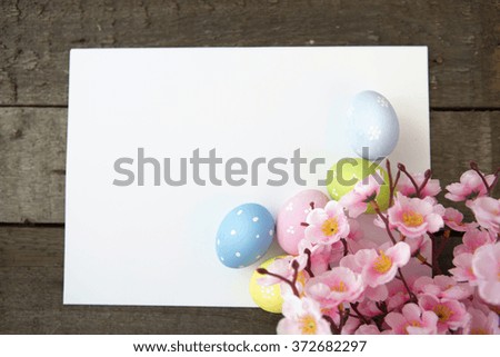 Easter eggs and blank note on wooden background. Happy easter.