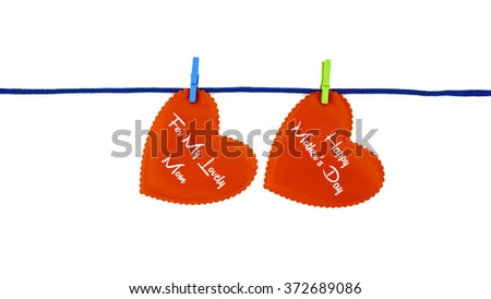 2 red love shapes with text FOR MY LOVELY MOM HAPPY MOTHER'S DAY clipped on blue rope isolated on white background