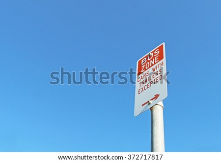 red and white Bus Zone sign in a blue sky