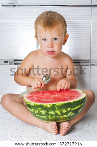 A child is eating watermelon with a spoon