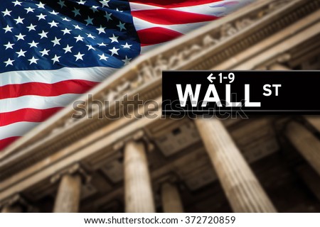 Wall Street sign with American flag on the background.