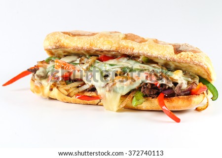 Tasty beef steak sandwich with onions, mushroom and melted provolone cheese in a ciabatta Royalty-Free Stock Photo #372740113