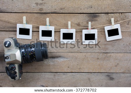 Valentine's day background,Photo frames hanging on a rope and old camera on wooden background.