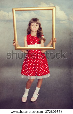 Beautiful girl in vintage spotted dress holding an empty frame. Photo in retro style with old textured paper.