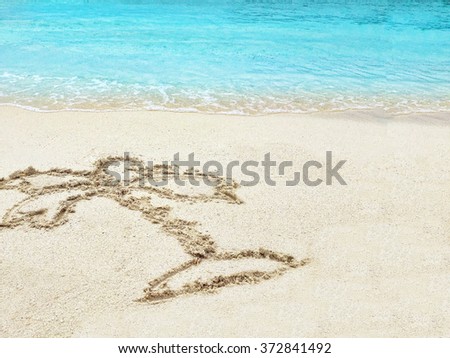 Drawing "Palm-tree" in the sand on a tropical island,  Maldives.