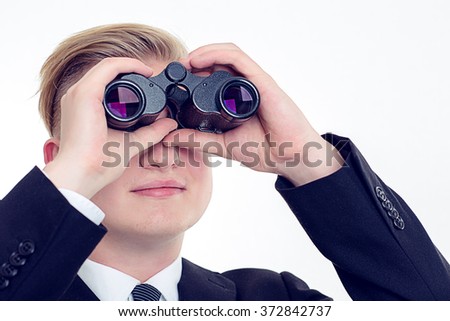 young business man is looking through binoculars