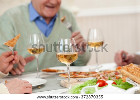 Cheerful mature parents are dining with son