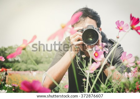 man photographer taking photos of flowers