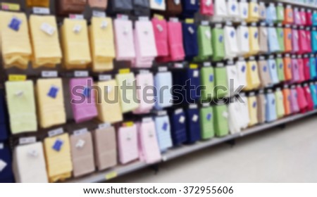 Blurred image of multicolor towels on shelves in department store