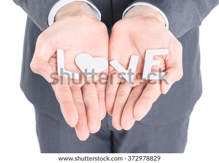 Business man show word love jigsaw piece isolated on white background