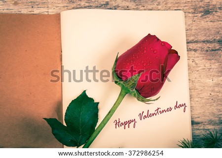 love text on notebook and red rose flower