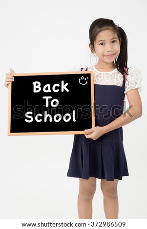 Asian girl holding blank chalkboard on gray background
