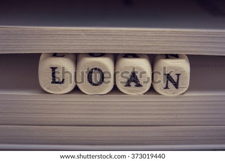 Wooden Blocks with text Loan and book pages