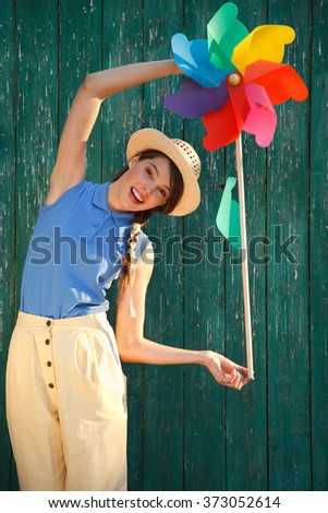 Young happy funny (vintage) dressed woman with colorful weather vane,looking like flower
 Picture ideal for illustating woman magazines.
