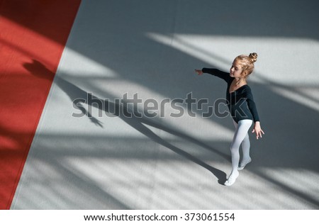 Girl practicing rhythmic gymnastics in the gym