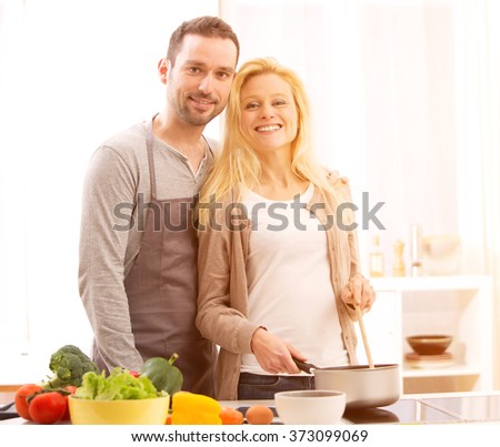 View of a Young attractive couple cooking in a kitchen