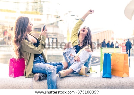 Two pretty girls having fun while shopping outdoors - Best female friends spending time together