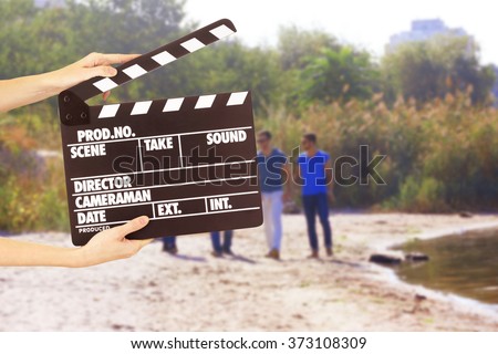 Operator holding clapperboard during the production of film outdoor
