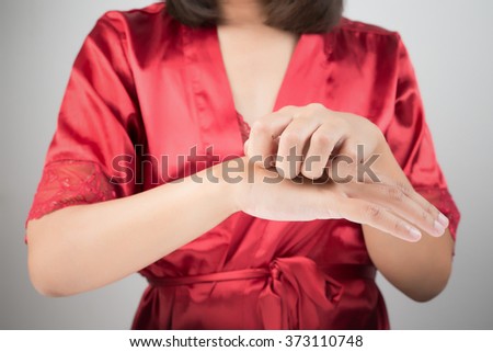 Woman scratching her arm.