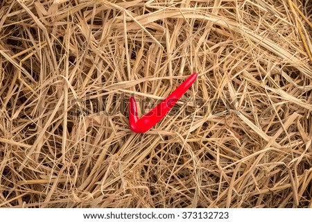 red check mark icon on hay background texture