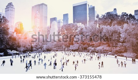 Ice skaters having fun in New York Central Park in fall with sunrise effect