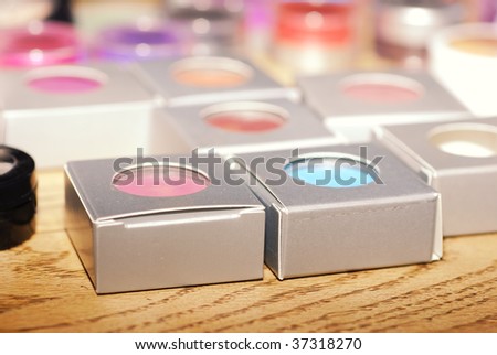 Boxes of multicolored eye shadow displayed on table