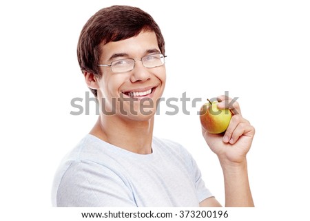 Close up portrait of young hispanic man in glasses and t-shirt smiling perfect toothy smile and holding fresh apple in his hand isolated on white background - education or healthy lifestyle concept