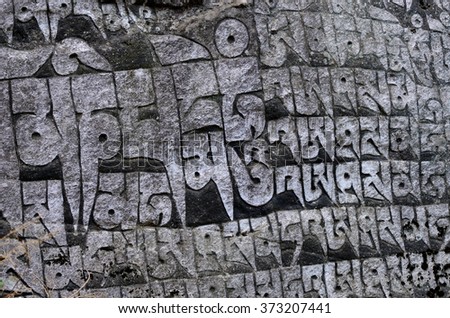 Ancient buddhist carved stone wall with sacred religious mantras written in tibetan language,Eastern Nepal, Everest region,Asia