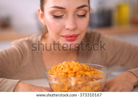 Smiling attractive woman having breakfast in kitchen interior
