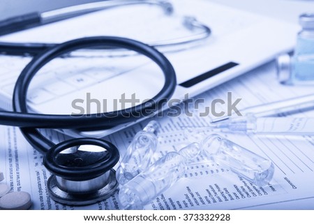 medical devices on the table at the doctor on a light background with wooden texture with blue toned