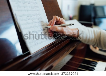 writing notes on sheet music close-up Royalty-Free Stock Photo #373339021