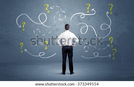 A salesman in doubt can not find the solution to the problem concept with curvy lined arrows and question marks drawn on urban wall