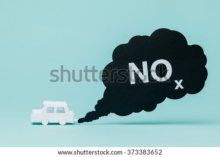 Little paper car creating nitrogen oxide emissions while running. Royalty-Free Stock Photo #373383652