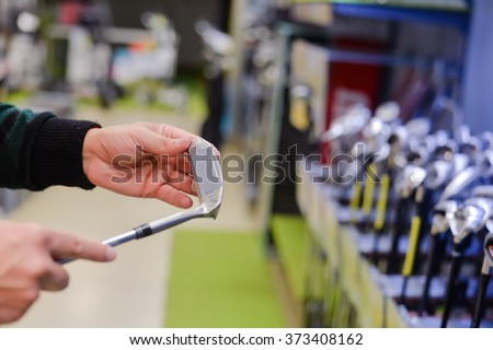 Man holding in hand golf club at a Golf Shop. Closeup photo