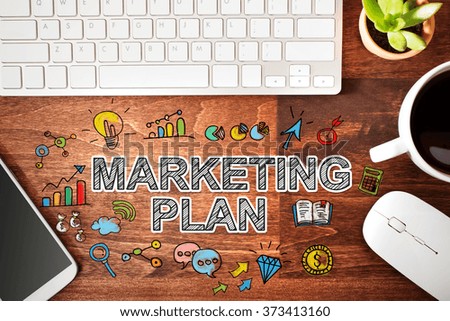 Marketing Plan concept with workstation on a wooden desk 
