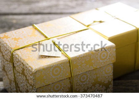 two golden gift boxes on old wood table background