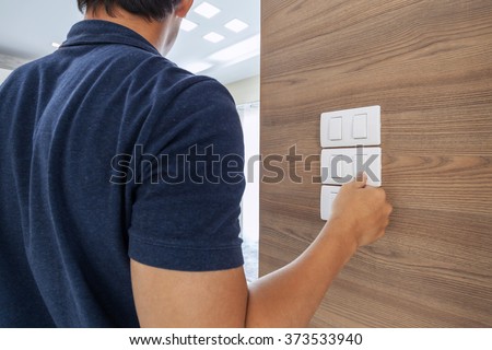 men switching off the light ,saving concept Royalty-Free Stock Photo #373533940