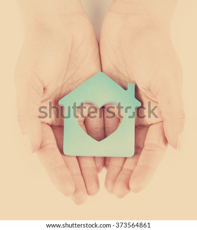 Female hands with model of house on light background