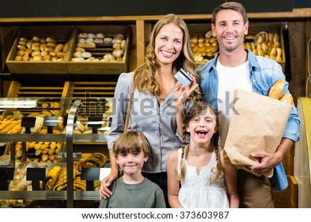 Portrait of family showing credit card in grocery store