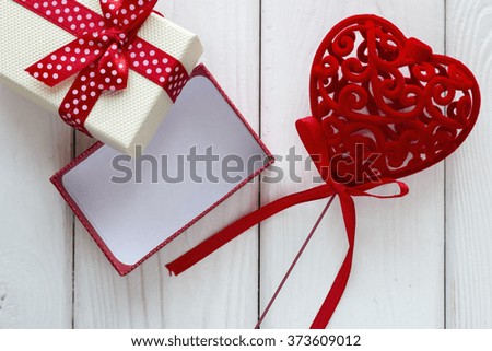 velvet heart with a bow near the gift box on a white background