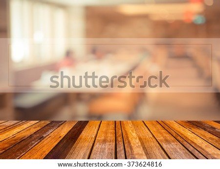 Abstract blur image of empty restaurant with wood table and chairs for background usage.(vintage tone)