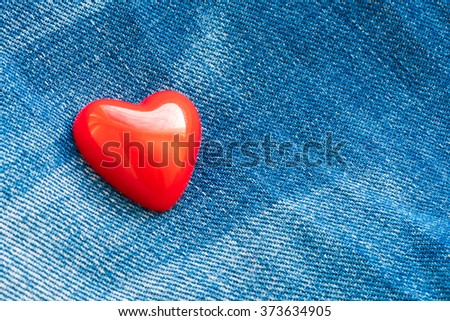 Red heart on denim background