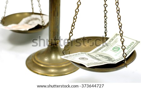 Pound and dollar notes on scale in a conceptual photo