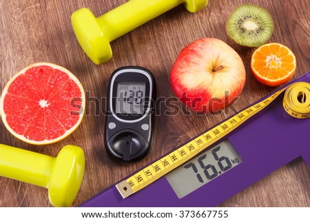 Electronic bathroom scale and glucose meter with result of measurement weight and sugar level, healthy food and dumbbells for fitness, concept of healthy lifestyles, diabetes and slimming