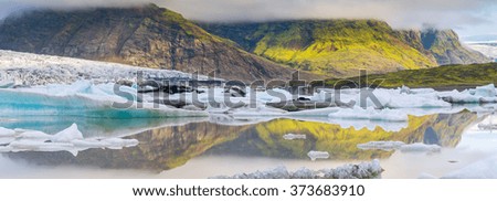 panorama of ice lagoon with blue iceberg and mountains in Iceland